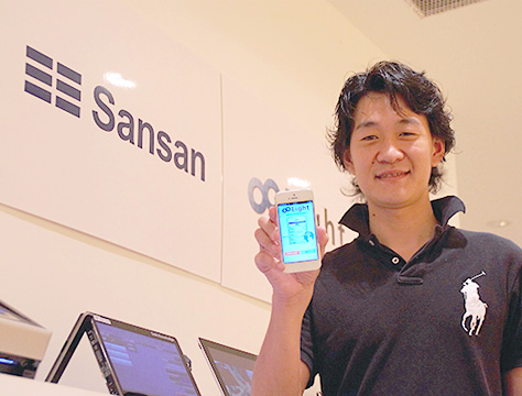 スマホを片手に持っているSansan Eight 事業部マーケティングマネージャーの千住 氏の写真