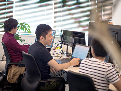 社員3人が横並びでPC作業をしている写真
